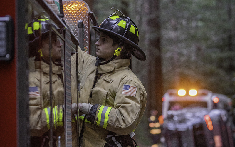 Felton Fire firefighter on top of a fire engine